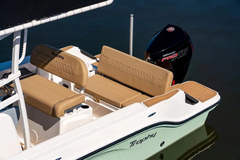 Slide: The Image of 2024 Bayliner Trophy 20CX boat with tan seating and powerful outboard motor. - 7