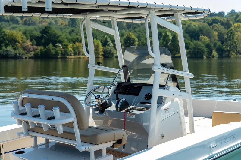 Slide: The Image of 2024 Bayliner Trophy 20CX boat on a calm lake, featuring a modern helm and seating. - 9