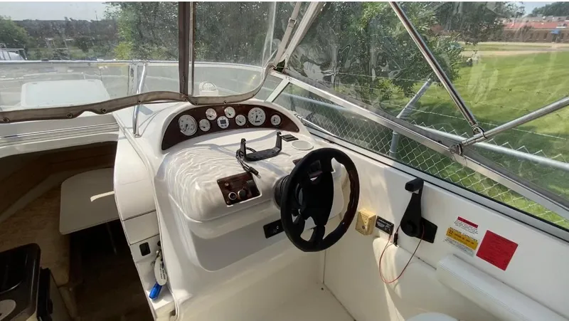 Slide: The Image of 2001 Larson 254 Cabrio boat cockpit with steering wheel and instrument panel. - 10