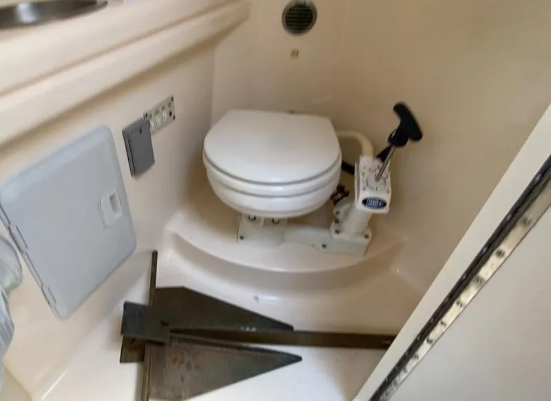 Slide: The Image of 2001 Larson 254 Cabrio boat bathroom with toilet and anchor storage. - 6