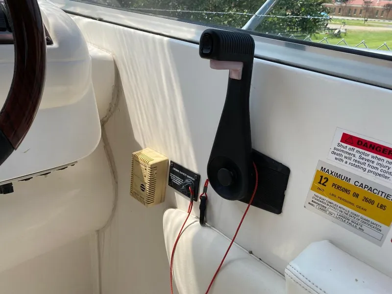 Slide: The Image of Interior of 2001 Larson 254 Cabrio boat showing controls and safety warning label. - 9