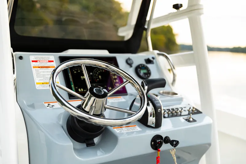 Slide: The Image of 2024 Bayliner Trophy 22CC boat dashboard with steering wheel and controls. - 18