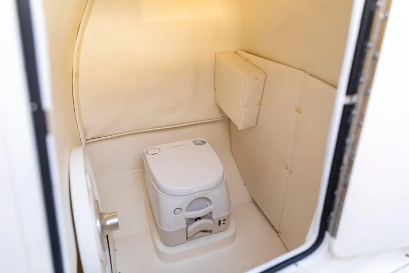 Slide: The Image of 2024 Bayliner Trophy 22CC boat interior with compact marine toilet. - 24