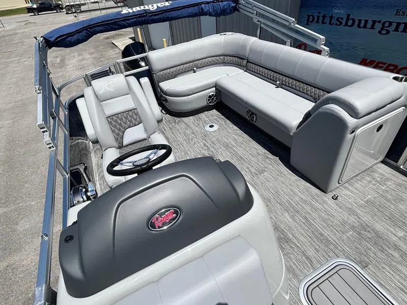 Slide: The Image of 2025 Ranger Reata 223C pontoon boat with luxurious seating and modern steering console. - 9