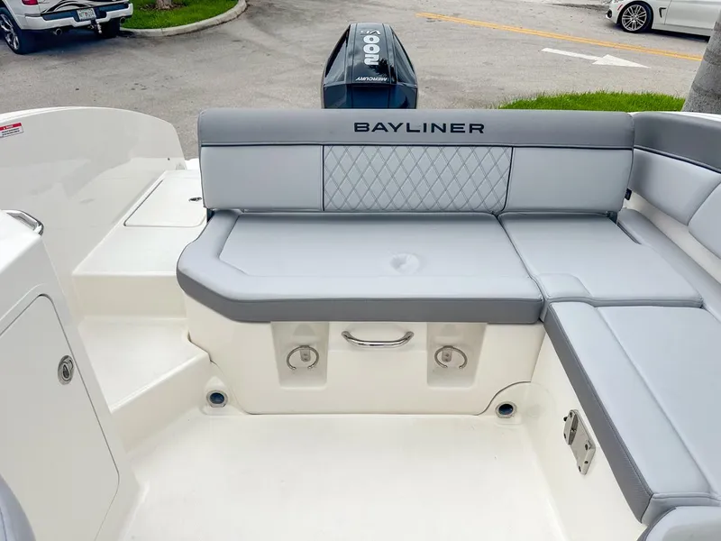 Slide: The Image of 2024 Bayliner DX2200 boat interior with gray seating and Bayliner logo. - 12
