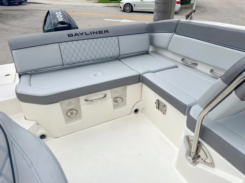 Slide: The Image of 2024 Bayliner DX2200 boat interior with gray seating and storage compartments. - 13