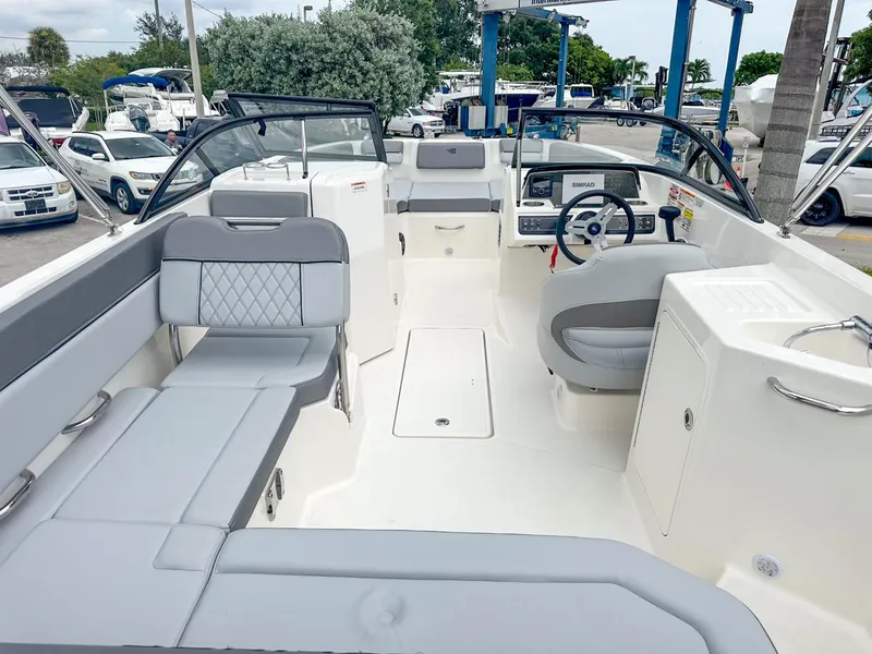 Slide: The Image of 2024 Bayliner DX2200 boat interior with gray seating and modern dashboard. - 14