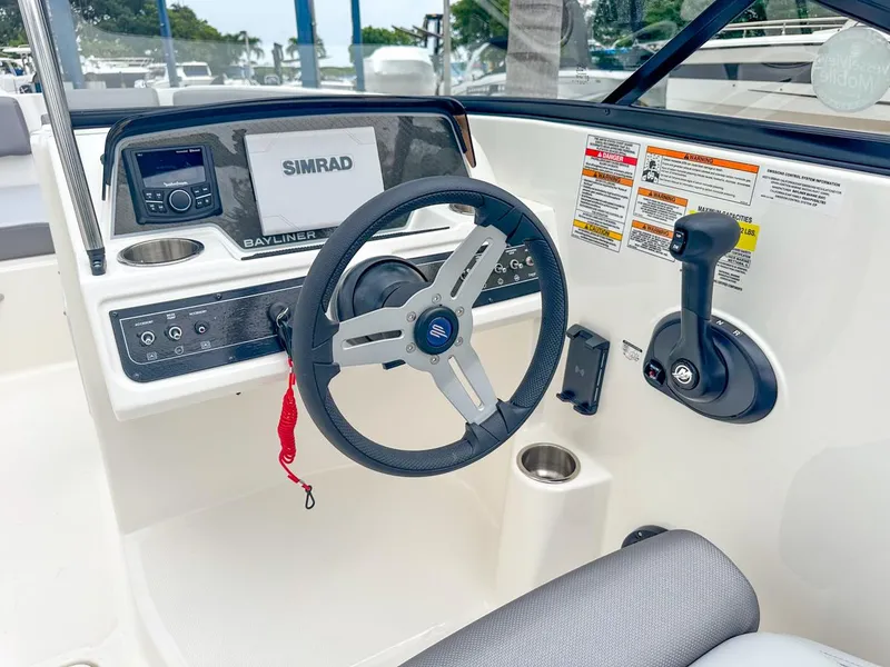 Slide: The Image of 2024 Bayliner DX2200 boat dashboard with steering wheel and Simrad navigation system. - 21