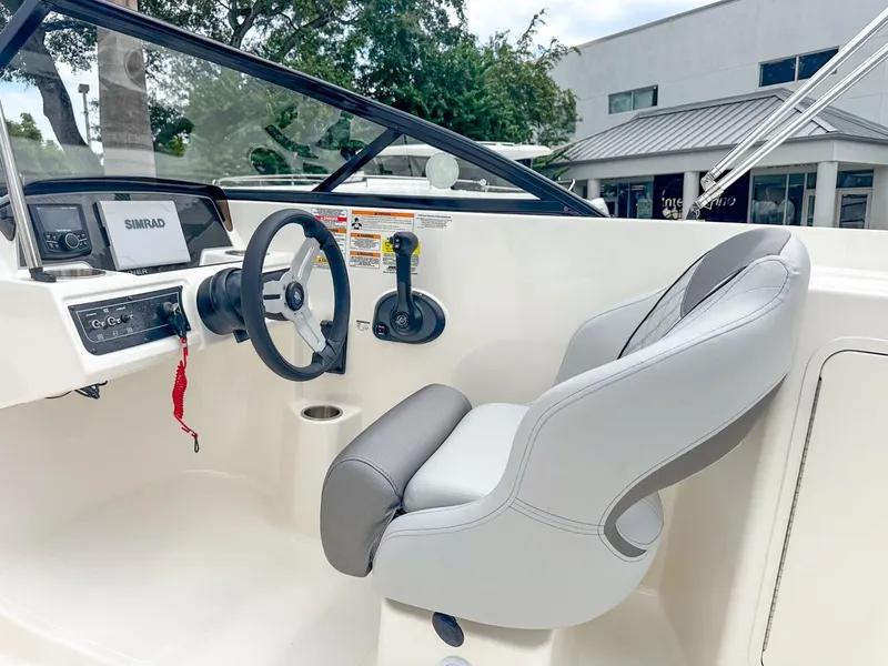 Slide: The Image of 2024 Bayliner DX2200 boat cockpit with steering wheel and control panel. - 22