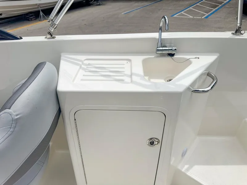 Slide: The Image of 2024 Bayliner DX2200 boat interior with sink and storage cabinet. - 24