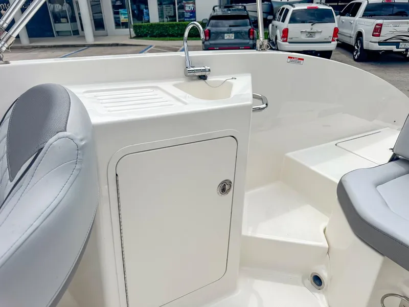 Slide: The Image of 2024 Bayliner DX2200 boat interior with sink and seating area. - 25