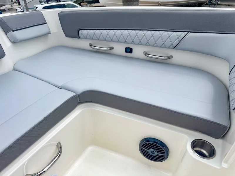 Slide: The Image of 2024 Bayliner DX2200 boat interior with gray cushioned seating and stainless steel accents. - 32