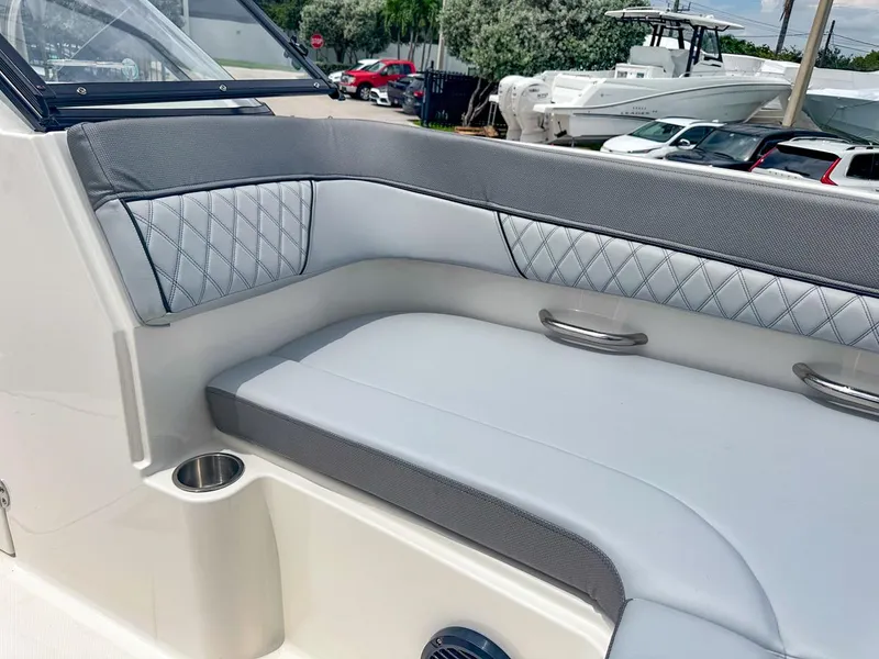 Slide: The Image of 2024 Bayliner DX2200 boat interior with gray cushioned seating and stainless steel accents. - 34