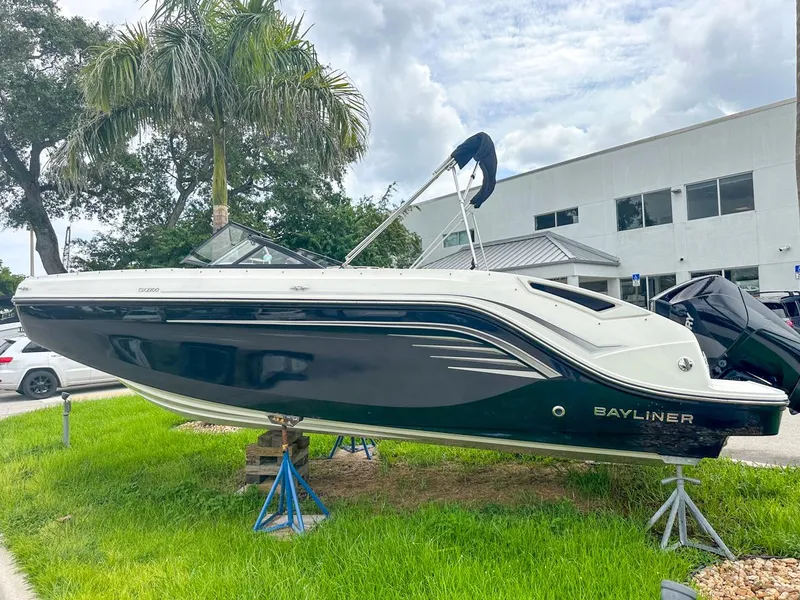 Slide: The Image of 2024 Bayliner DX2200 boat displayed outdoors on stands, with a modern design and sleek black hull. - 7