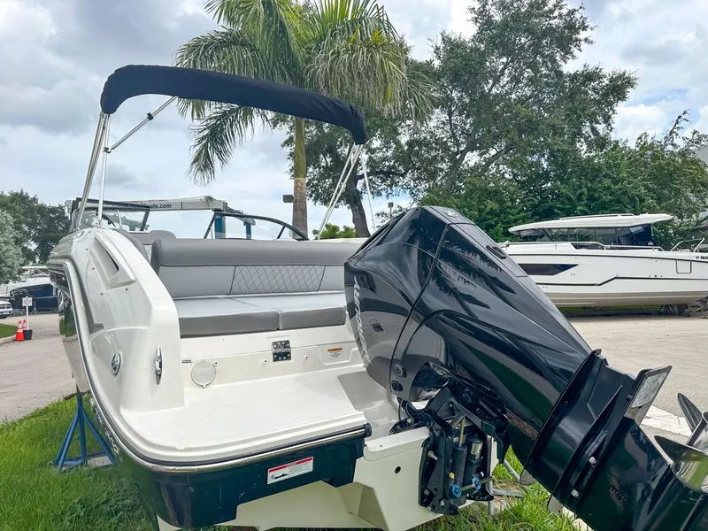 Slide: The Image of 2024 Bayliner DX2200 boat with outboard motor, parked outdoors near palm trees. - 9