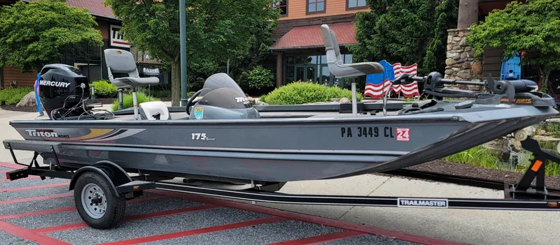 Slide: The Image of 2002 Triton 175 Sport boat on trailer, parked outdoors with visible Mercury engine. - 1