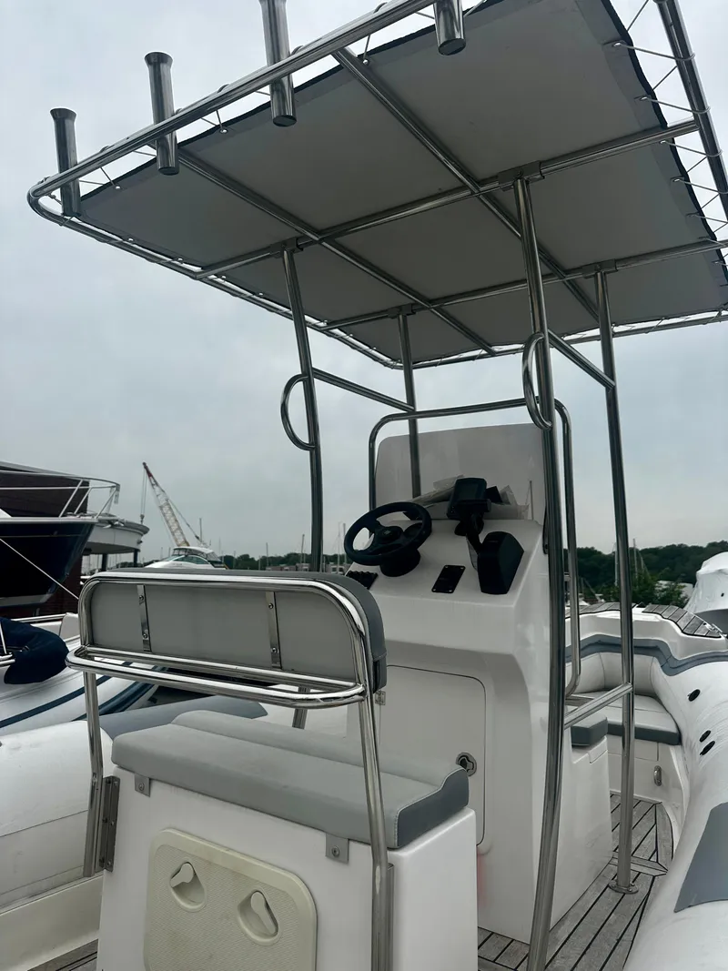 Slide: The Image of 2021 Hedia Rib580 boat with steering console and canopy, docked at marina. - 4