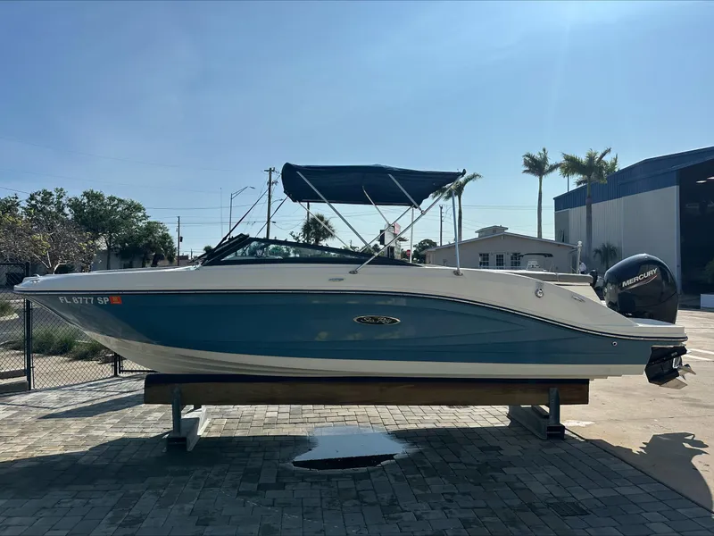 Slide: The Image of 2020 Sea Ray SPX 230 OB boat on display with blue hull and canopy. - 1