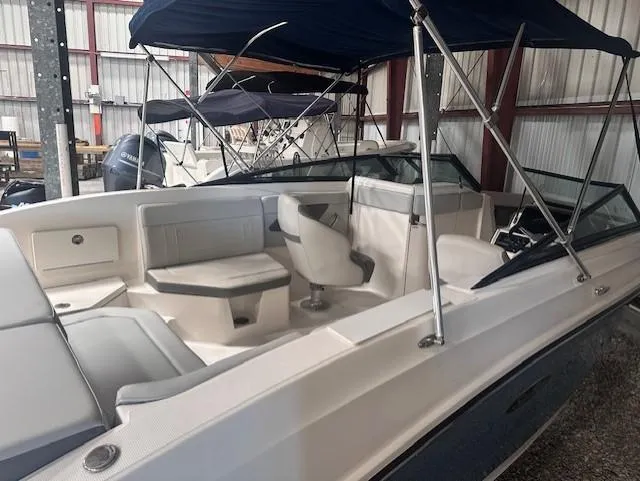 Slide: The Image of 2020 Sea Ray SPX 230 OB boat interior with seating and canopy in storage. - 12