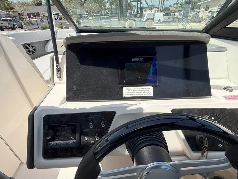 Slide: The Image of 2020 Sea Ray SPX 230 OB dashboard with steering wheel and navigation display. - 19