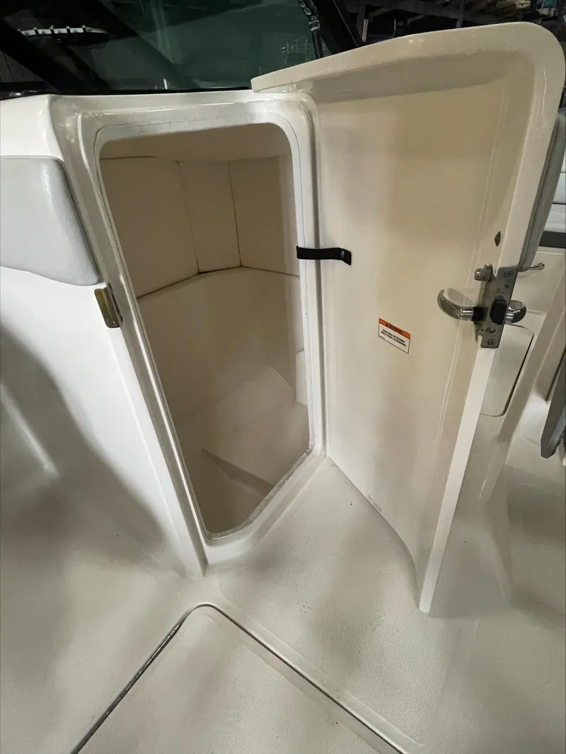 Slide: The Image of 2020 Sea Ray SPX 230 OB boat storage compartment with open door. - 25