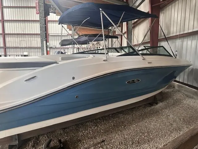Slide: The Image of 2020 Sea Ray SPX 230 OB boat with blue hull, stored indoors. - 5