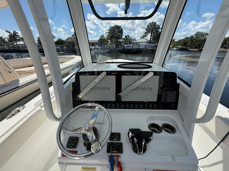 Slide: The Image of 2023 Sea Hunt Gamefish 25 helm with Garmin displays, steering wheel, and controls. - 10