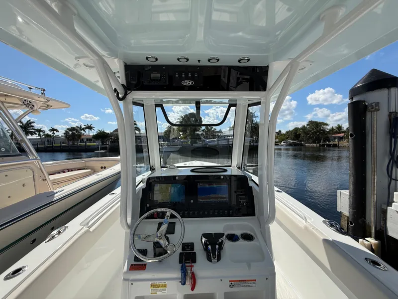 Slide: The Image of 2023 Sea Hunt Gamefish 25 boat cockpit with steering wheel and navigation equipment. - 16