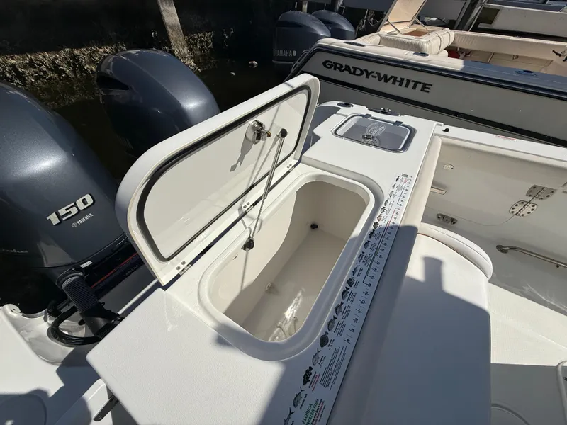 Slide: The Image of 2023 Sea Hunt Gamefish 25 boat with open storage compartment and dual engines. - 22