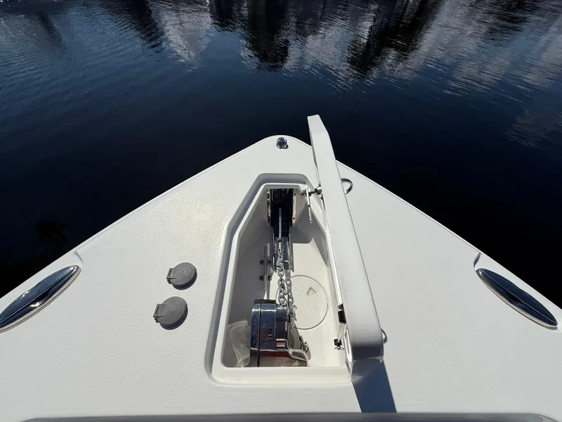 Slide: The Image of 2023 Sea Hunt Gamefish 25 boat bow with anchor compartment open on calm water. - 24
