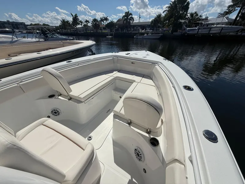 Slide: The Image of 2023 Sea Hunt Gamefish 25 boat interior with white seating, docked by the water. - 26