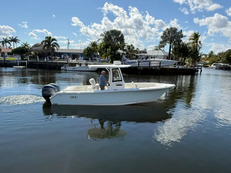 Slide: The Image of 2023 Sea Hunt Gamefish 25 boat cruising on a calm, sunny waterway. - 6