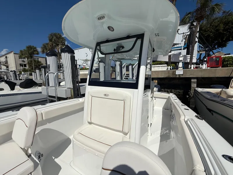 Slide: The Image of 2023 Sea Hunt Gamefish 25 boat with sleek design and comfortable seating at a marina. - 9