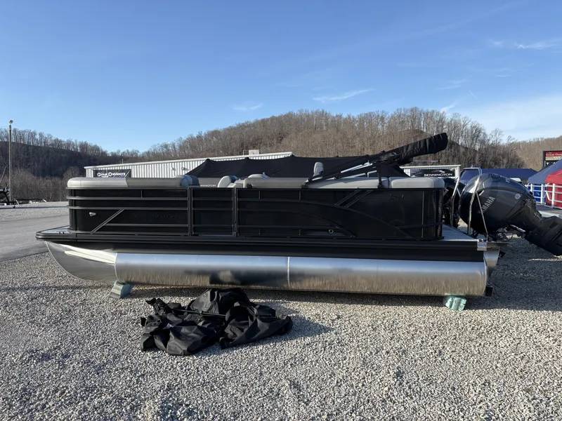 The Image of 2025 Bennington 21 SLSE pontoon boat on gravel lot, clear sky background. - 1