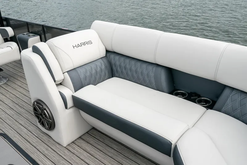 Slide: The Image of 2023 Harris 250 Sunliner Sport boat interior with white and gray seating, cup holders, and speaker. - 20