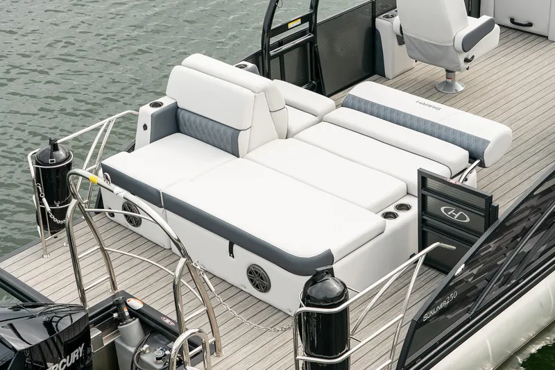 Slide: The Image of 2023 Harris 250 Sunliner Sport boat with luxurious seating on a calm water surface. - 8