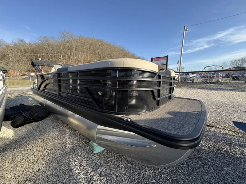 The Image of 2025 Bennington 23 SL pontoon boat on gravel lot under clear blue sky. - 1