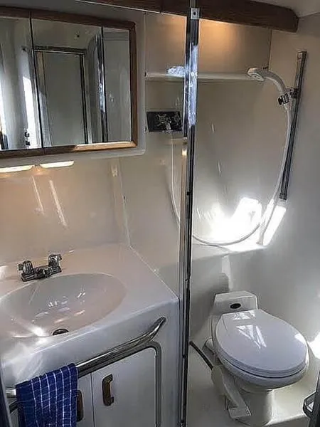 Slide: The Image of 1994 Sea Ray 370 Express Cruiser bathroom with sink, mirror, and shower. - 3