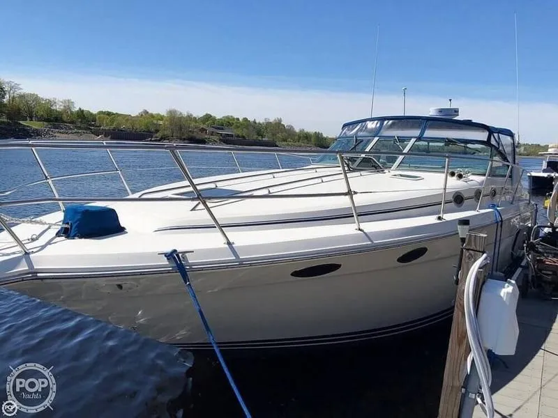 Slide: The Image of 1994 Sea Ray 370 Express Cruiser cabin with cozy bed and porthole windows. - 4