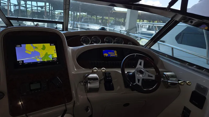 Slide: The Image of 2004 Sea Ray 380 Sundancer helm with navigation screens and steering wheel. - 12