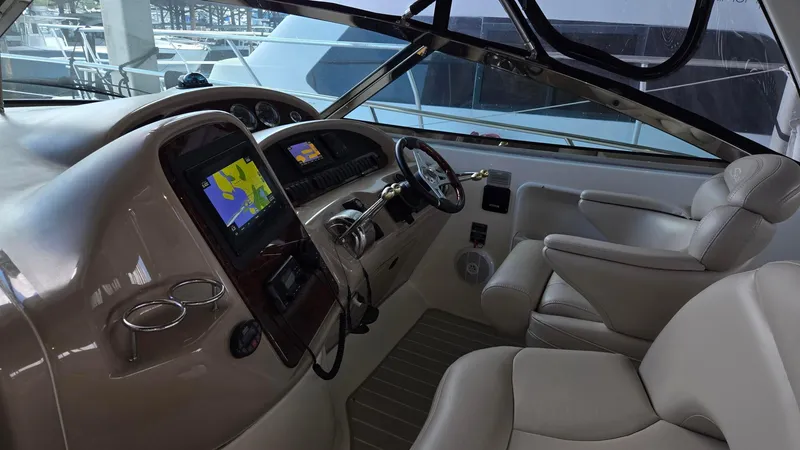 Slide: The Image of 2004 Sea Ray 380 Sundancer cockpit with navigation system and plush seating. - 14