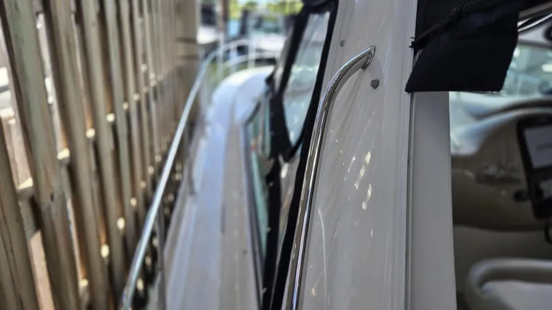 Slide: The Image of 2004 Sea Ray 380 Sundancer boat side view with railing and interior glimpse. - 2