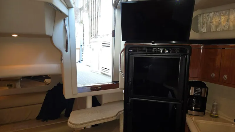 Slide: The Image of Interior of 2004 Sea Ray 380 Sundancer yacht with kitchenette and seating area. - 29