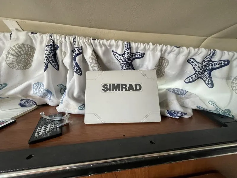 Slide: The Image of Simrad device on Stingray 250CS boat, 2014, with nautical-themed curtain backdrop. - 11
