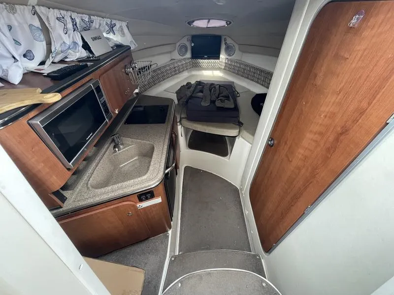 Slide: The Image of 2014 Stingray 250CS cabin interior with kitchenette, sink, and sleeping area. - 9