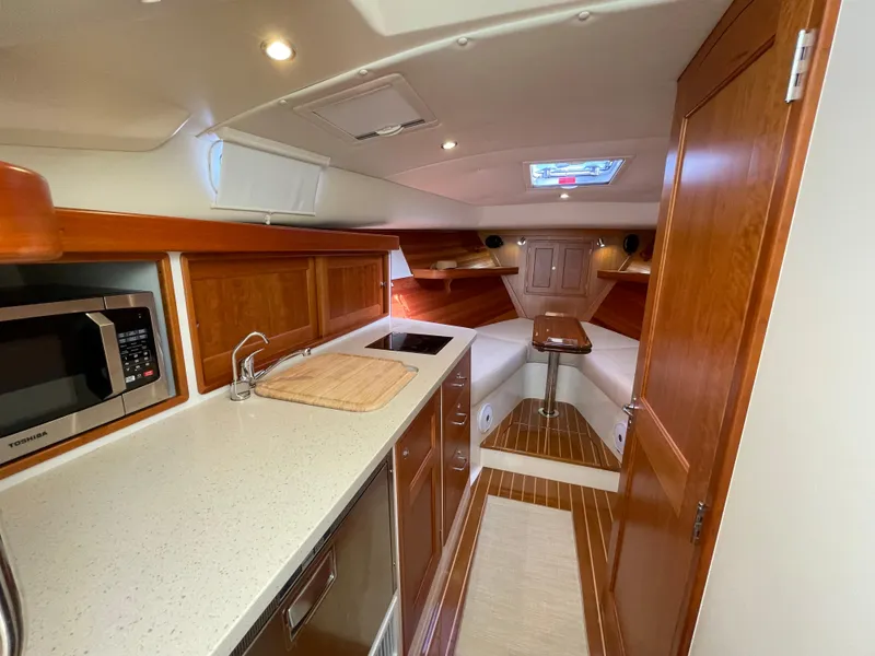 Slide: The Image of 2020 MJM 35z yacht interior with modern kitchen, wood cabinetry, and cozy seating area. - 18