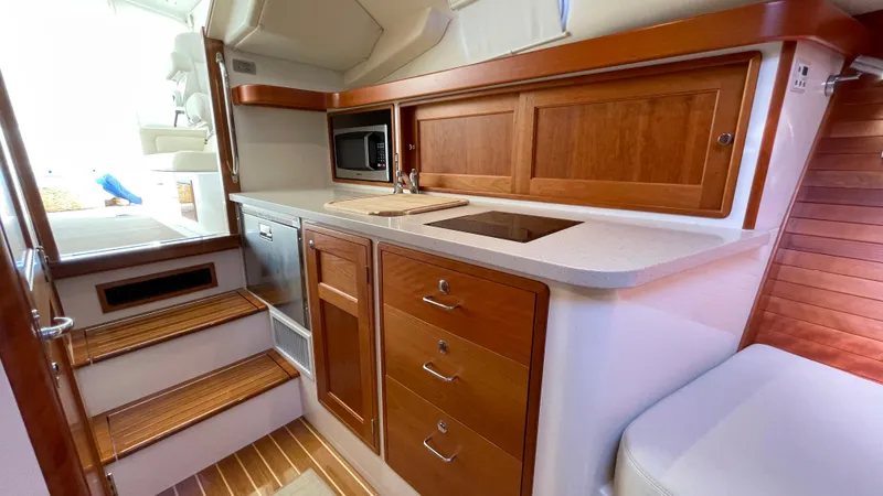 Slide: The Image of 2020 MJM 35z yacht interior with wooden cabinetry and compact kitchen area. - 21