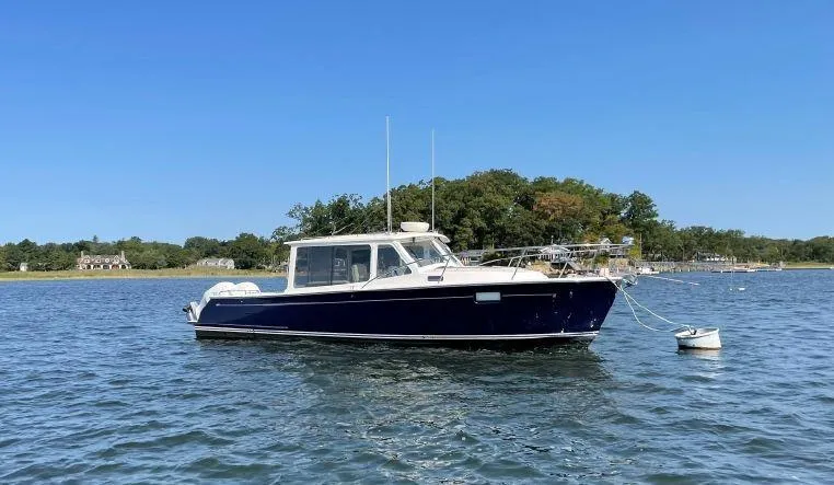 Slide: The Image of 2020 MJM 35z boat anchored on calm water with trees in the background. - 28