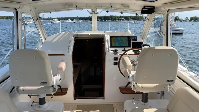 Slide: The Image of 2020 MJM 35z boat cockpit with dual seats and navigation system on a sunny day. - 8