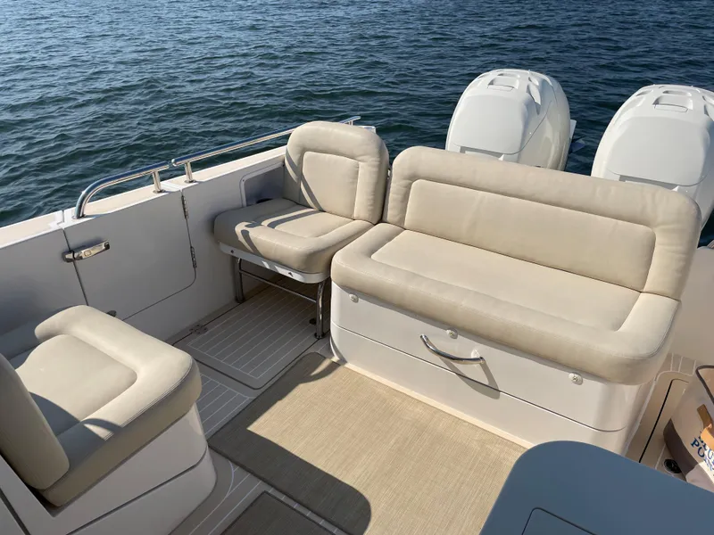Slide: The Image of 2020 MJM 35z boat interior with beige seating and twin engines on the water. - 9